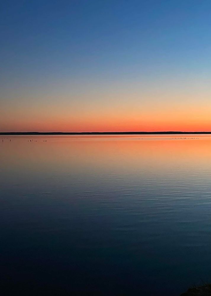 a Rothko view of late June water and sky above below a far inked line horizon, far want and peace aglow in the midst of blue