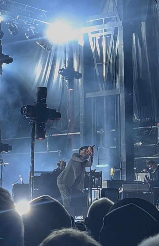 Thåström på scenen, med sitt typiska scenspråk och den obligatoriska svarta hatten på huvudet. Grå kostym. 