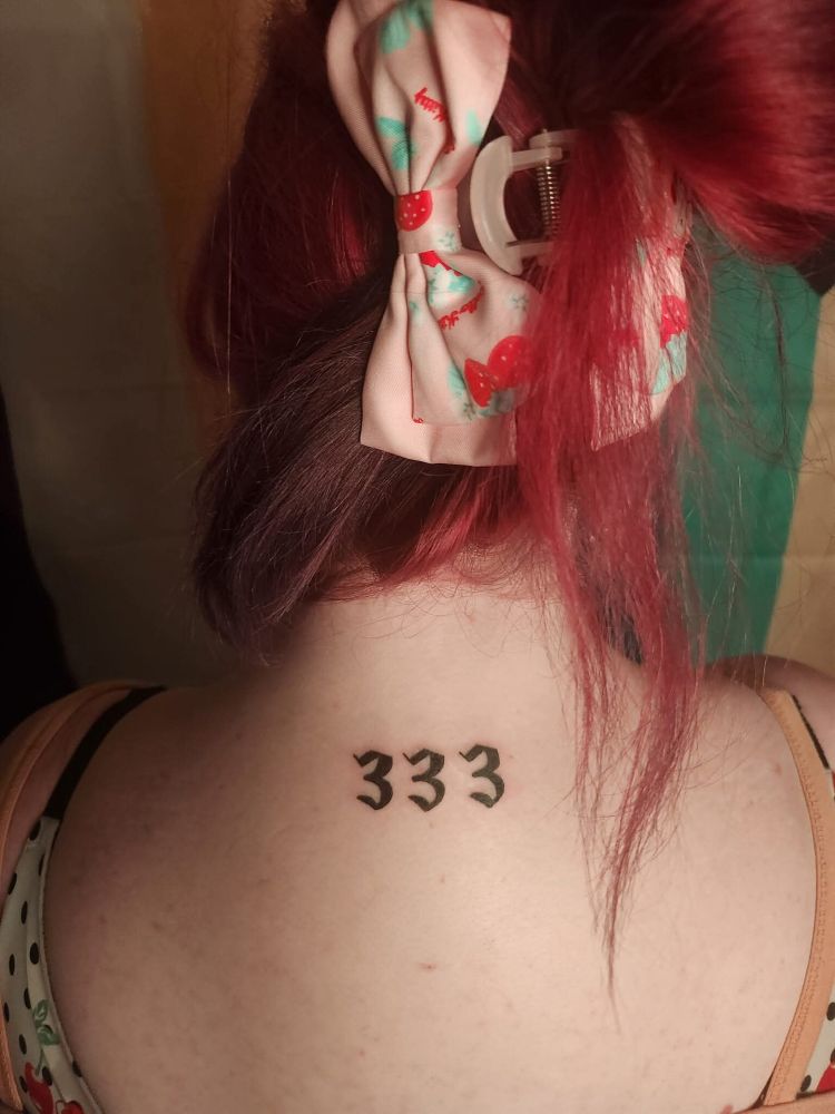 A picture of Goddess Brooklyn’s new 333 angel number tattoo on their upper back