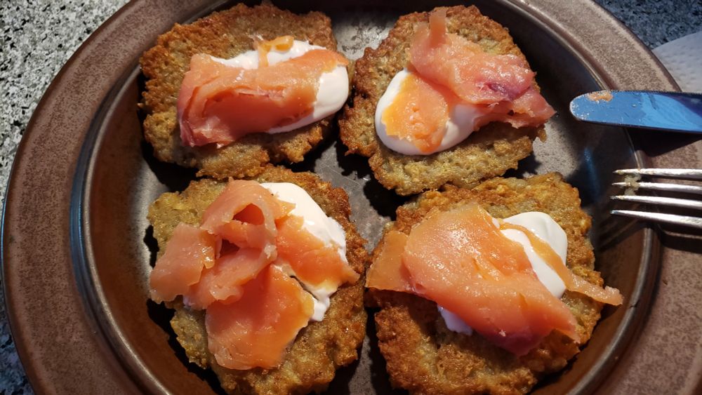 4 potato pancakes topped with sour cream and smoked salmon. 
