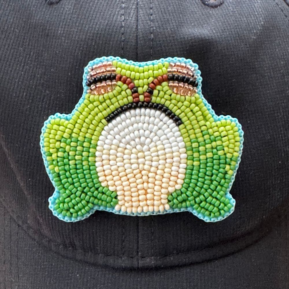 A pacific tree tree made of beads. you looking at the frog head on. It is beaded with shades of
light green body and shades of cream and white for underbelly
with golden eyes.