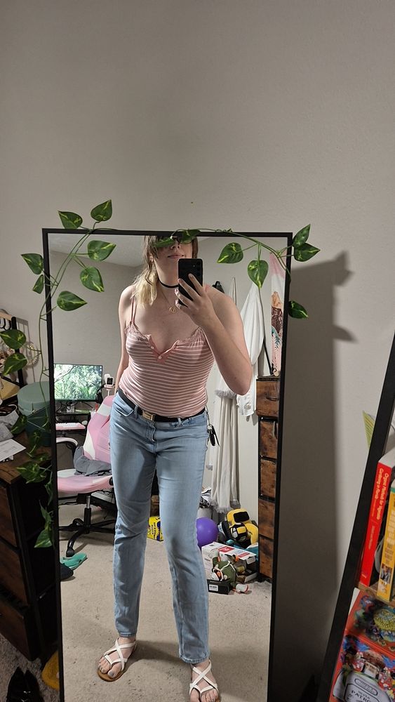 Still me in a light pink striped cami and lightwash midrise jeans. I look really hot trust me