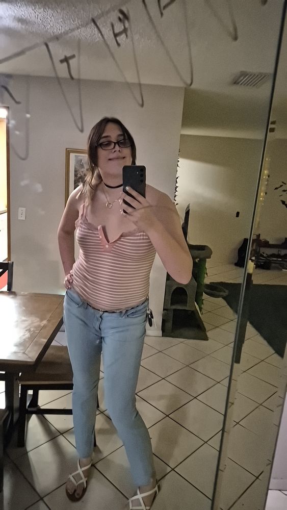 Me in a light pink striped cami and lightwash midrise jeans