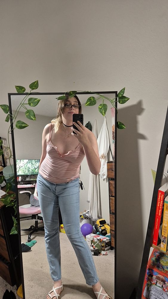 Also me in a light pink striped cami and lightwash midrise jeans