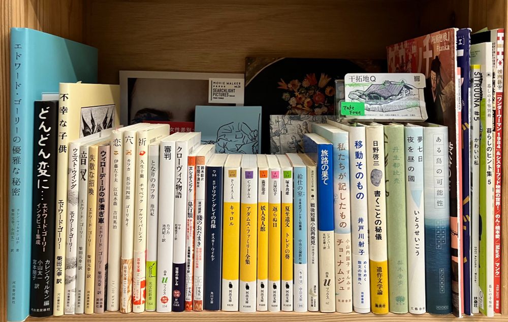 木の本棚に本が並ぶ。ゴーリー、カフカ、幻想小説など。