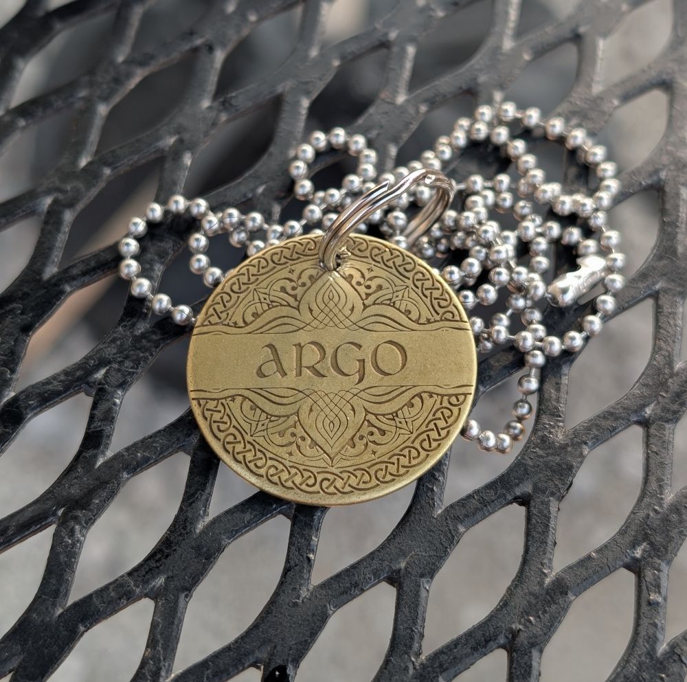 Pic of a dog name tag on a chain. It's brass and says ARGO