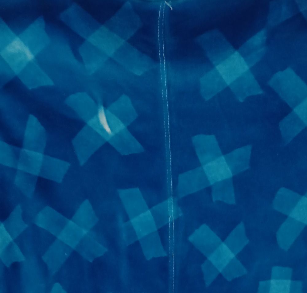 Just a patterned blueprint on cotton. 
A pinch of citric acid to deepen the blue. 
The patterns are realised with simple tape arranged as irregular X. 