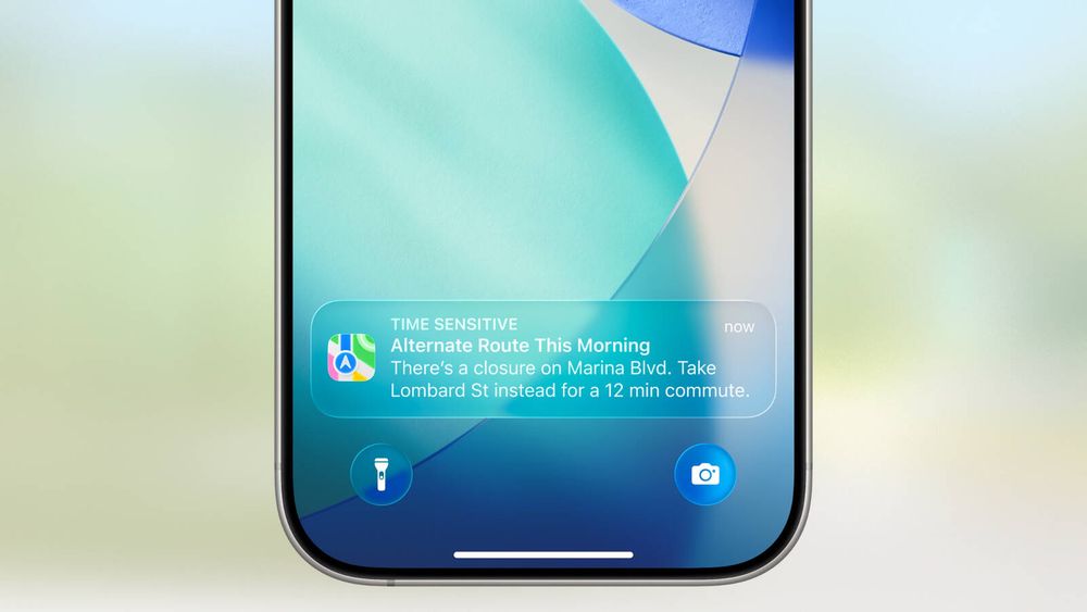 A notification on an iOS home screen with the new “liquid glass” design style that is hard to read due to white text on a light blue background
