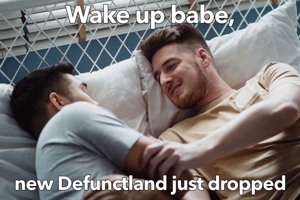 An image of two guys in bed, with one awake and gently grasping the other by the arm with the text "Wake up babe, new Defunctland just dropped".