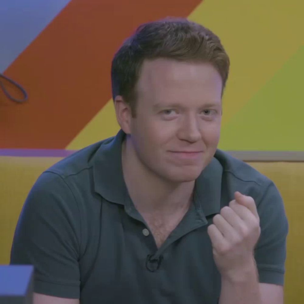 a man wearing a blue shirt with a microphone on his neck