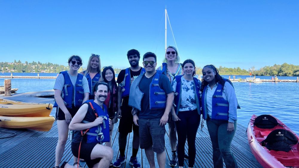 Members of the MatsuLab and Termini Lab on a dock wearing life vests after kayaking.