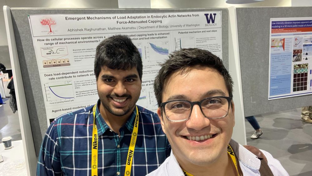 Abhishek and Matt smiling in front of Abhishek's poster