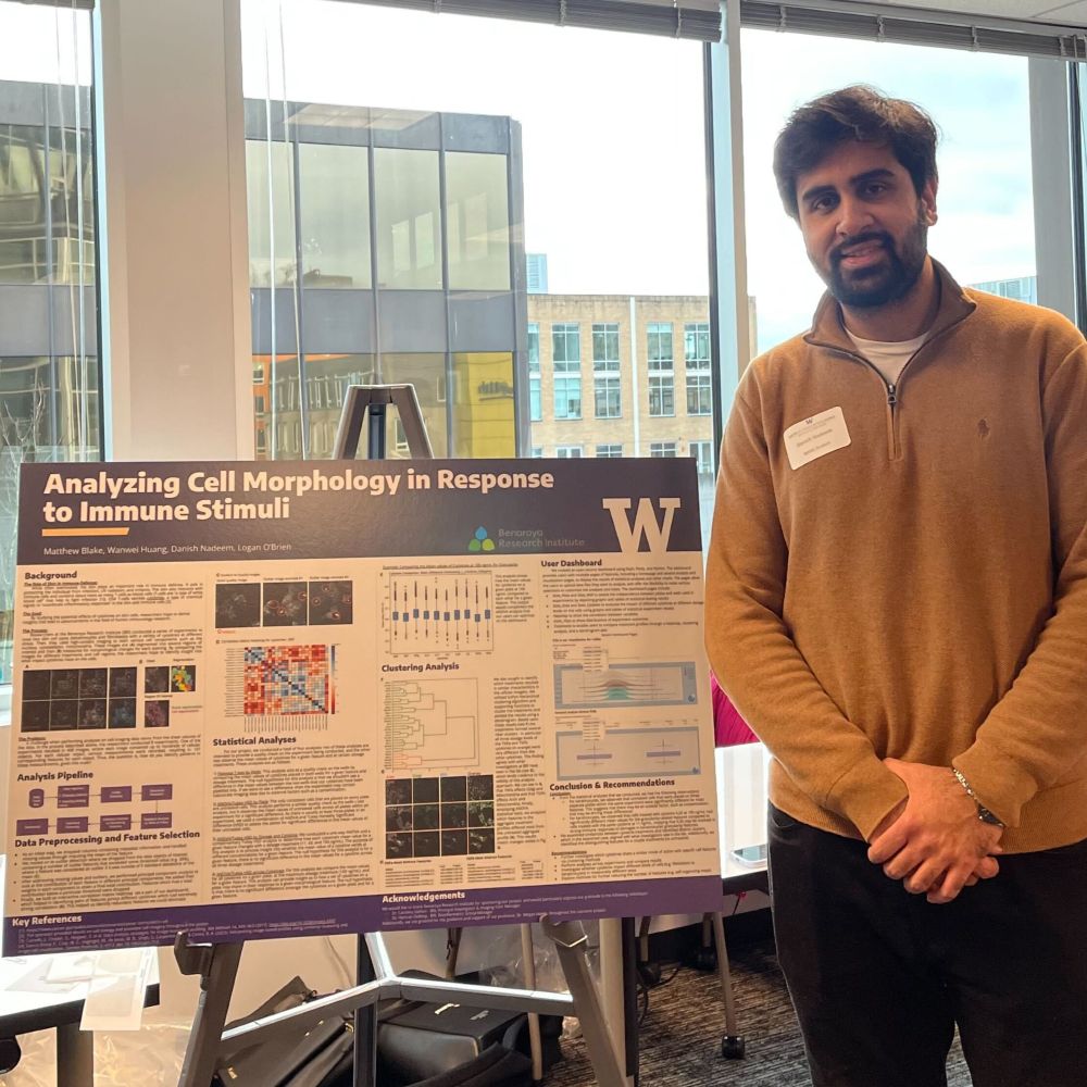 Danish stands next to his capstone project poster titled "Analyzing cell morphology in response to immune stimuli"