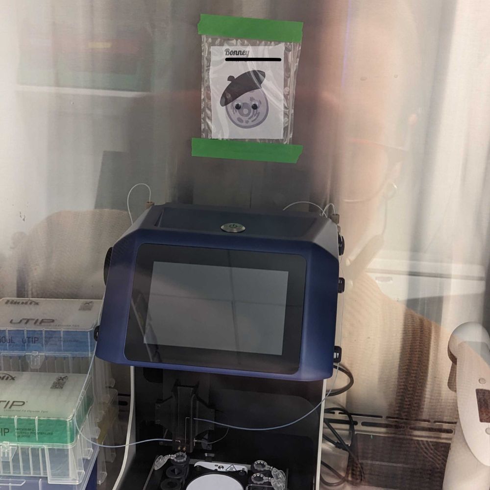 A laboratory instrument with above it a little sign with a cell wearing a beret and googley eyes, named "Bonney"