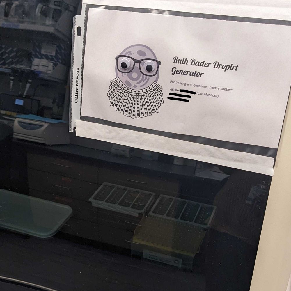 A sign of a cell wearing glasses and a RBG collar, with googley eyes, named "Ruth Bader Droplet Generator"