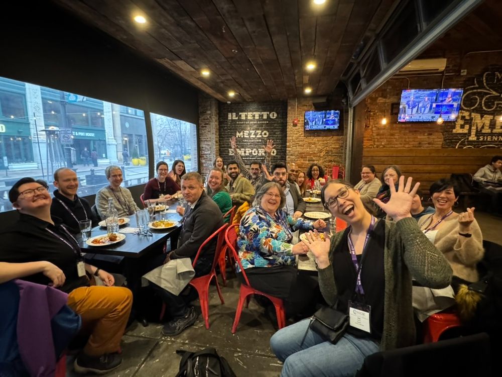 Two dozen Associate Editors, authors, and family members in an industrial Italian restraurant.