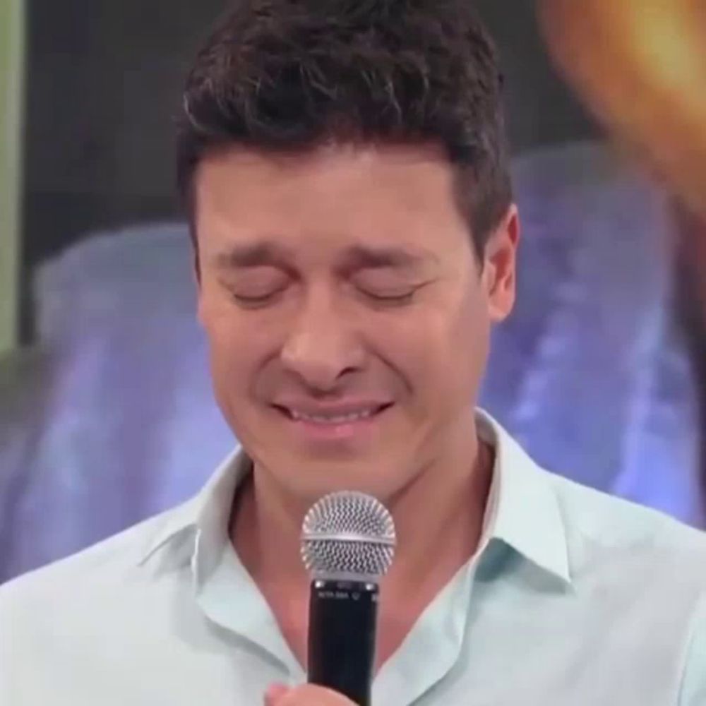 a man is crying while holding a microphone in his hand