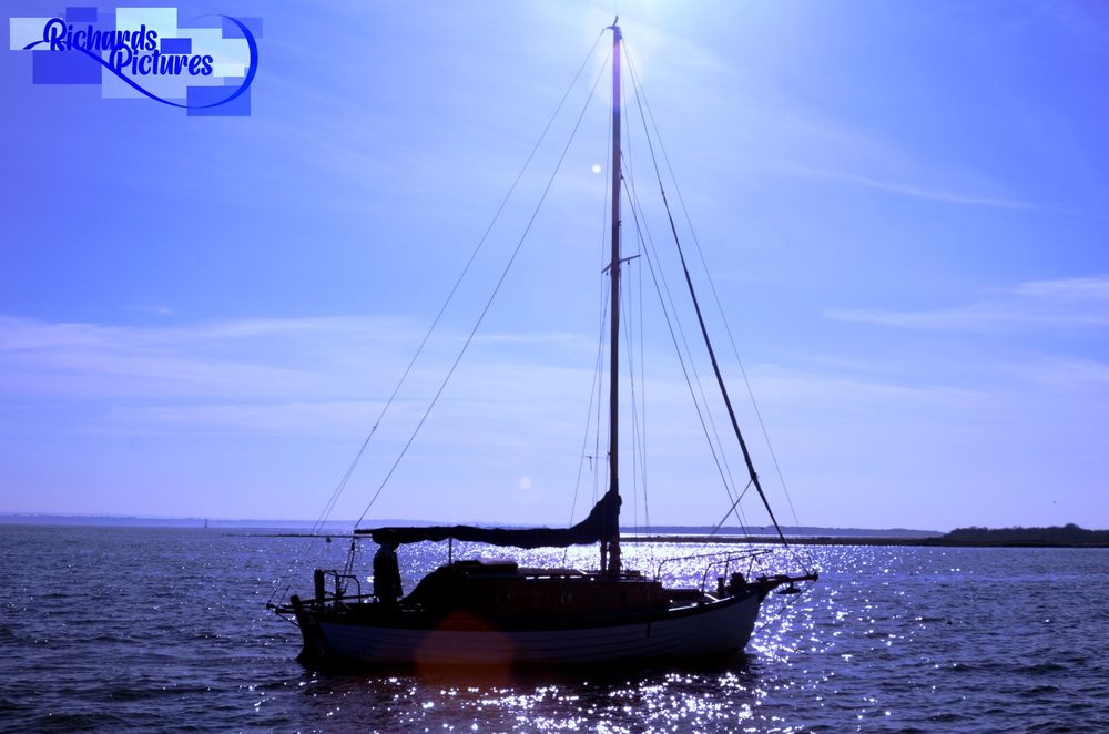 This boat was moving during this time. Fortunately, I captured the boat in a shot with the sunlight. 

-Canon EOS 100D with EF 28-90mm lens.
-F/11
-1/320sec
-ISO 100
-32mm focal length
-Taken around 15:50

-Used different levels of blue hue for the sea and sky. 
-Increased contrast on the boat to appear like a silhouette.
-Cropped the top half the line of the boat with the horizon line.  