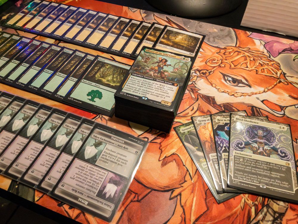 A photo of a playmat upon which a Magic: The Gathering deck is partially spread out into rows of matching basic lands and tokens.