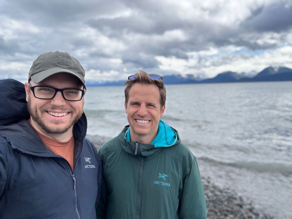 Two brothers standing on a rocky beach on an overcast day in Homer AK