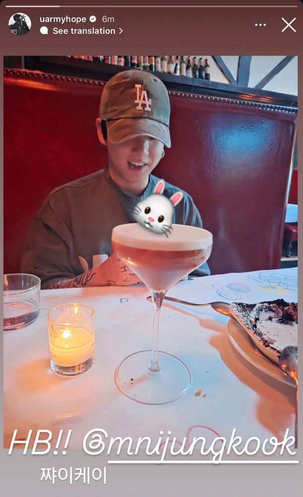 uarmyhope ig story showing jungkook as the birthday boy!!! says HB @mnijungkook and hangul written beneath. jk is wearing an LA hat with a gray shirt 