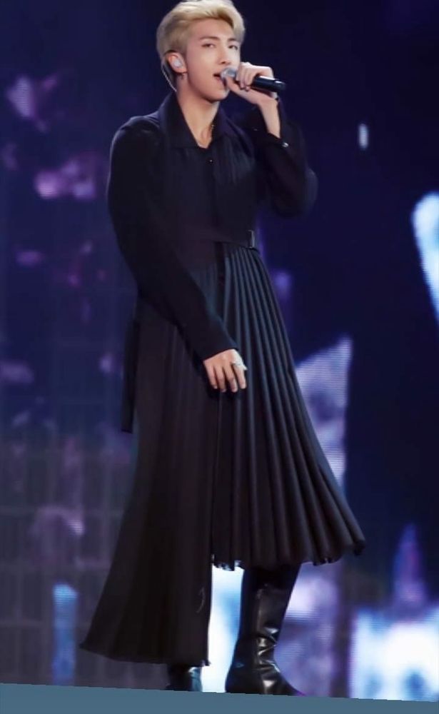 Namjoon in changing lives in an all black outfit with a long pleated skirt detail