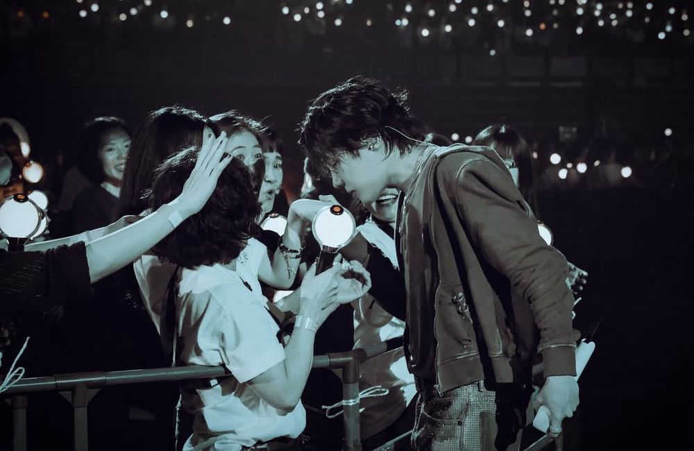 picture of hobi during his concert holding an army’s hand and his head is bowed