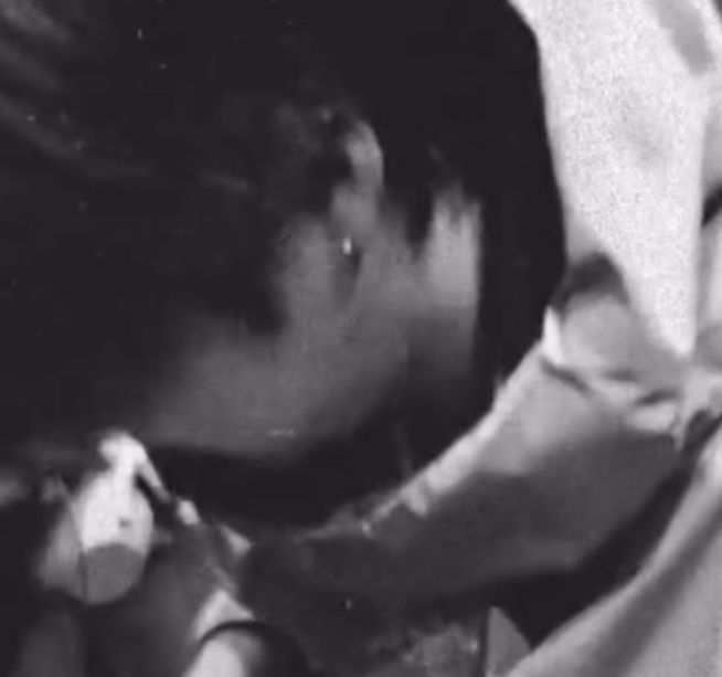 zoomed in screenshot of yoongi playing guitar and showing his earring on 