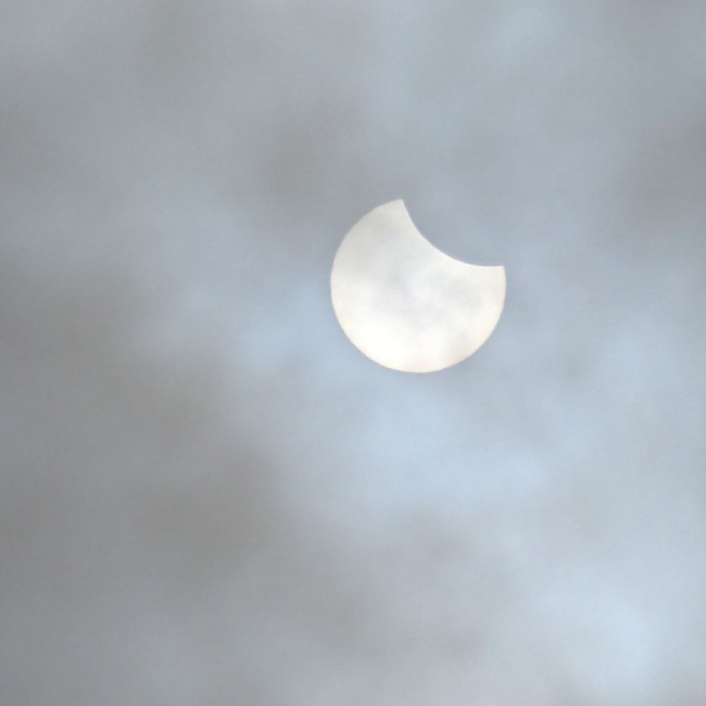 Sonne während der partiellen Sonnenfinsternis gestern, nur schemenhaft hinter Wolken zu erkennen .