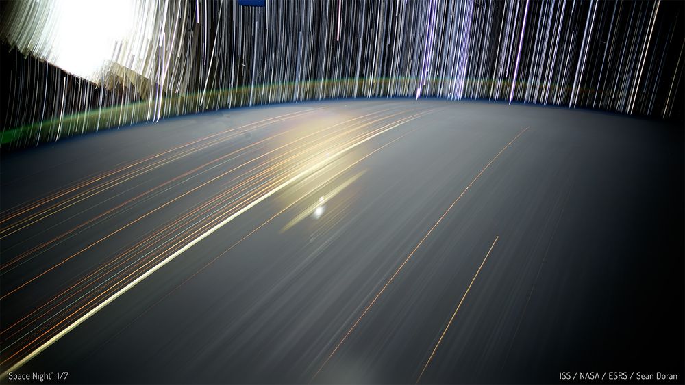 Stars and cities glowing in long exposure streaks of light as ISS orbits Earth. 