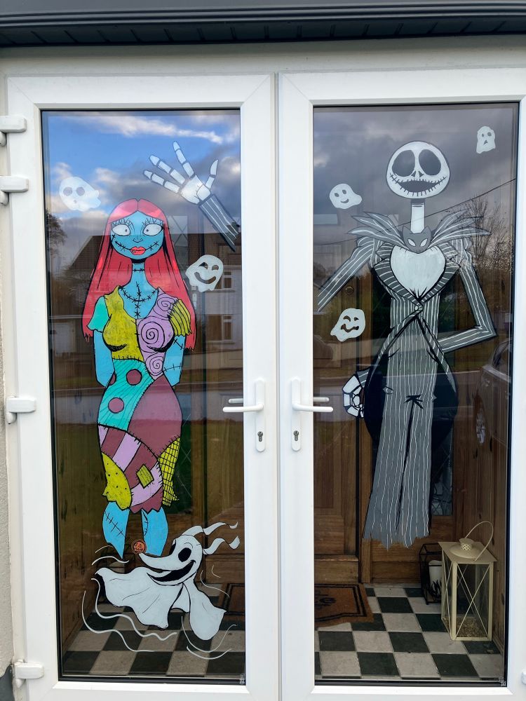 Halloween Window Paintings of Jack Skellington, Sally and Zero from the Nightmare before Christmas.  Surrounded by ghosts. All done with Posca Markers with the help of my Wife.  Jack specifically took a while to colour the strips.