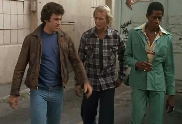 Screenstill from the Starsky and Hutch TV show. Starsky, Hutch and their friend Huggy walking in the streets. 200% 80's coolitude vibe.