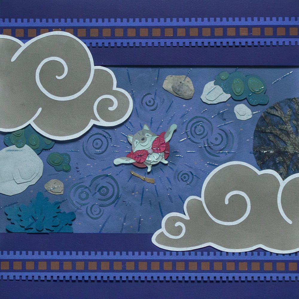 Illustration done with cut paper. The scene is from a bird eye view angle. In the middle, the wolf spreads his arms, while rain is falling around him. There are some rocks and vegetation around.
Two big grey clouds are going over the picture and beyond, one at the top left corner, and one at the bottom right corner.
There is a blue frame with repetitive patterns above and below the picture.