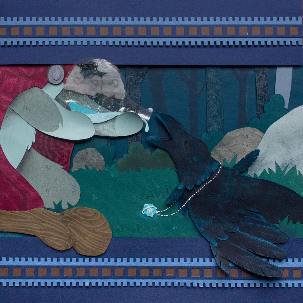 Illustration done with cut paper. The scene is a close-up. On the left, the wolf is kneeling, his walking cane on the ground, and and we don't see the top of his body. He is pouring the content of a vial into the ravens beak. The raven is on the left, still lying in the grass, and still with the blue necklace around its neck. Its wing is going out of the picture frame.
There is a blue frame with repetitive patterns above and below the picture.