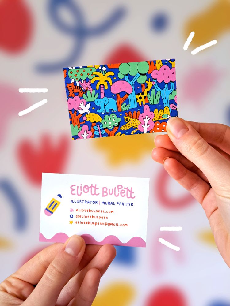 A photo of the back and front of my new business cards being held up. The front has a colourful jungle illustration and the back has my name and contact details next to a chunky drawing of a pencil. 