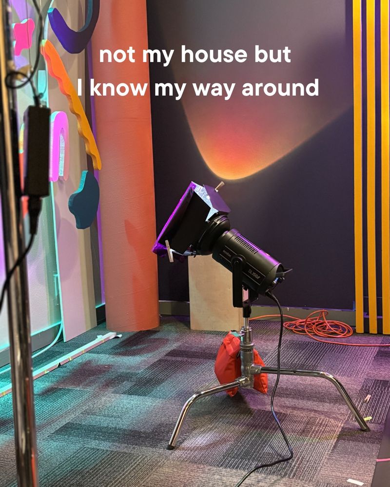 A glimpse of the new SciShow set with the new squiggles, a light, and a the blue & yellow arch wall.