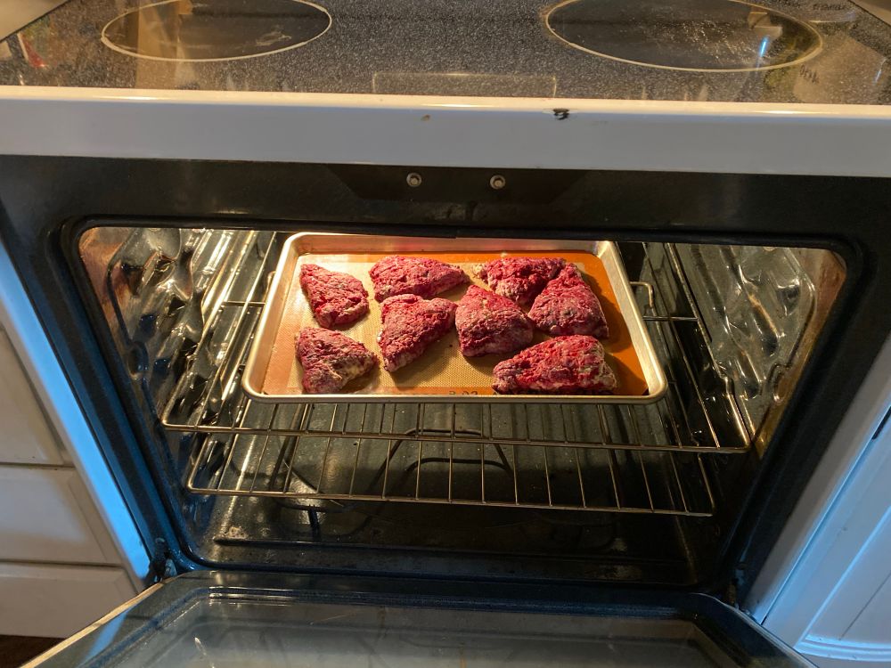 Inside an oven rests a tray of baked horrors meant to be raspberry scones but instead what you might find in a bin behind a shifty hospital. 