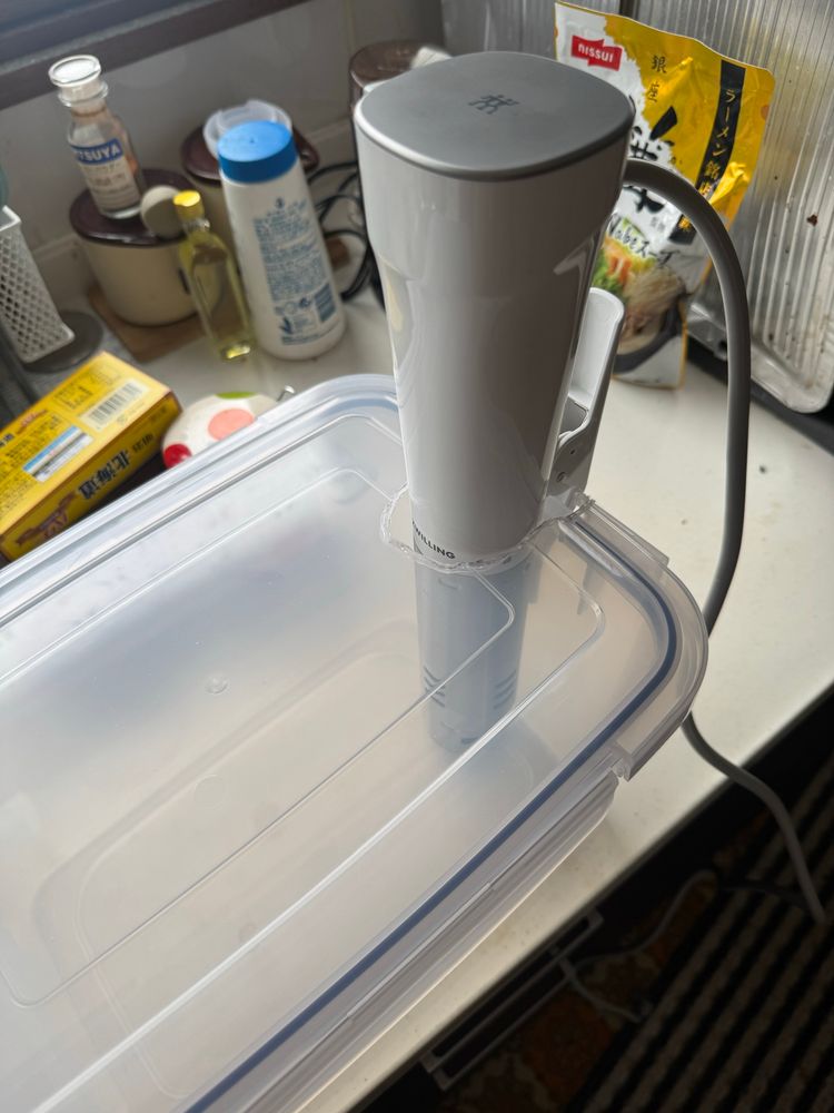 低温調理器がちょうど入る穴を開けられたプラスチックコンテナ