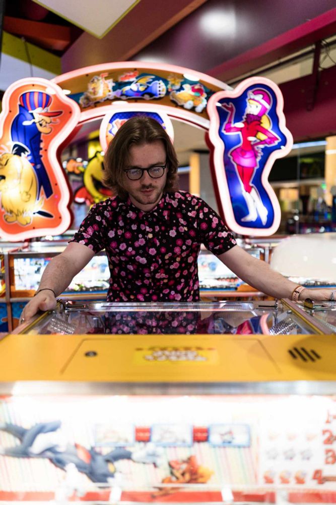 Scott, me, in a floral pink shirt with black base, the shoot takes place in an arcade.