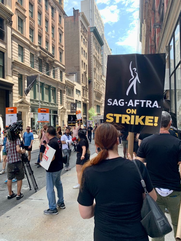 SAG-AFTRA picket line in NYC with a prominent sign that says “SAG-AFTRA on Strike”