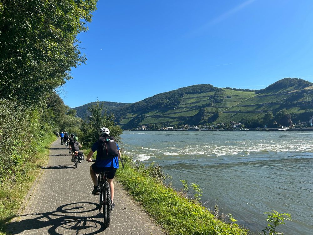 Schülergruppe fährt am Rhein Rad