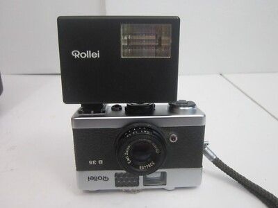 A Rollei 35B camera, upside down, with a Rollei flash affixed to the hot shoe, which is on the bottom of the camera. Photo lifted from an ebay.com listing.