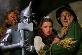 The Cowardly Lion, The Tin Man, Dorothy, and The Scarecrow startled by someone outside of picture, from "The Wizard of Oz."