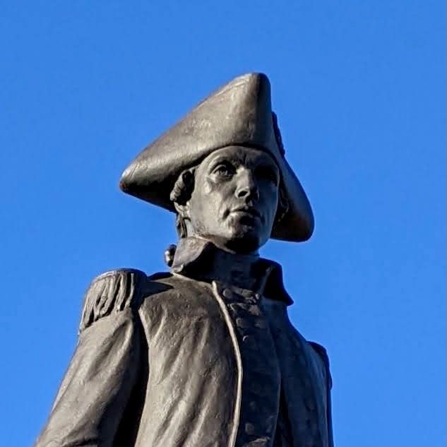 Bronze statue of a man in a tricorn hat and a military jacket