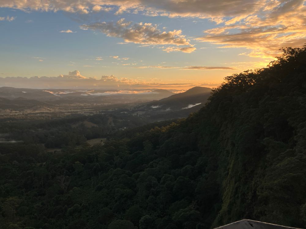 View of the Mary River valley in Australia from Mapleton Falls at sunset with a few clouds in the sky.