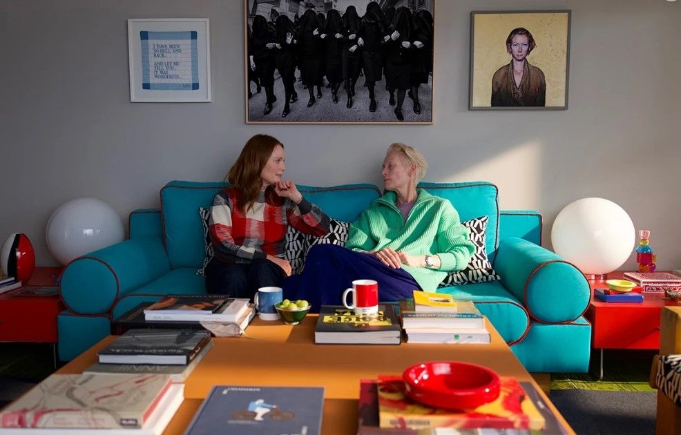 Tilda Swinton et Julianne Moore sur un canapé dans La chambre d'à côté.