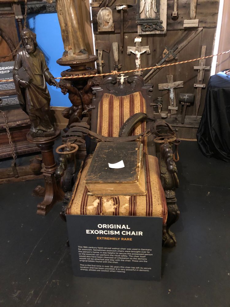 “Original exorcism chair. Extremely rare” 

A wooden chaise with leather straps. A large old book sits on top 