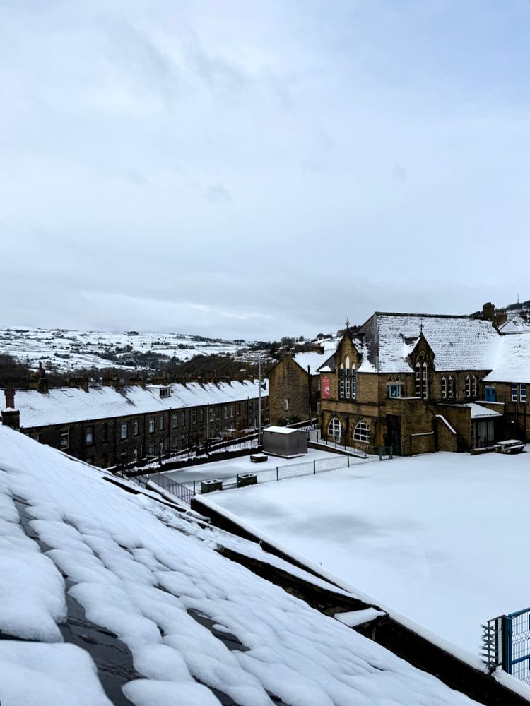 A view out of my home office velux window (in the roof) which looks up to the Pennines over our Primary School and town - everything is covered in snow