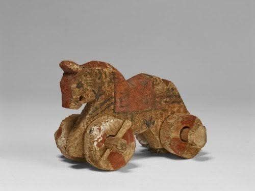 Toy horse on wheels, painted wood, 7.6 cm high by 11.5 cm long 
Roman Egypt, 1st-3rd century AD, found at Akhmim
The horse has a red painted blanket on its back, the wheels are affixed to the legs of the horse with dowels, one thru them legs and then thru the dowels themselves to assure the wheels stay in place