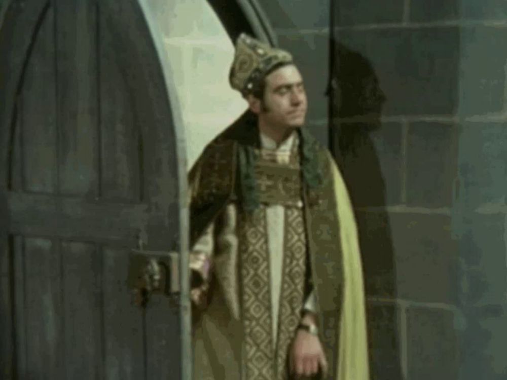 a man in a yellow cape is standing in front of a wooden door